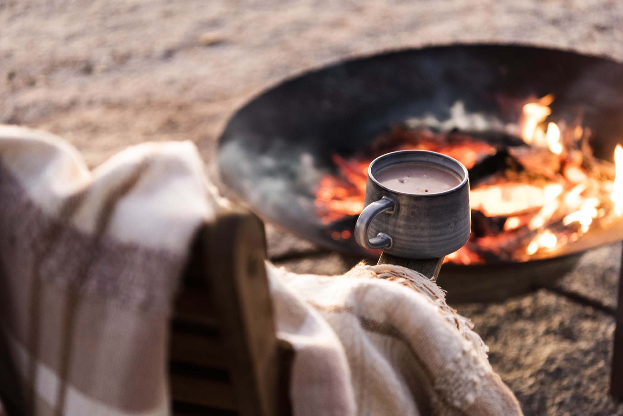 Chair with a blanket and mug over a fire